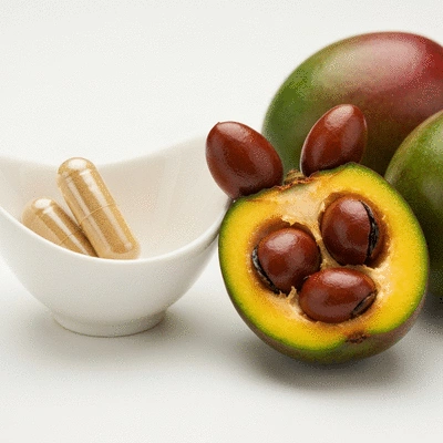 African mango supplement capsules and fresh fruit on a clean background